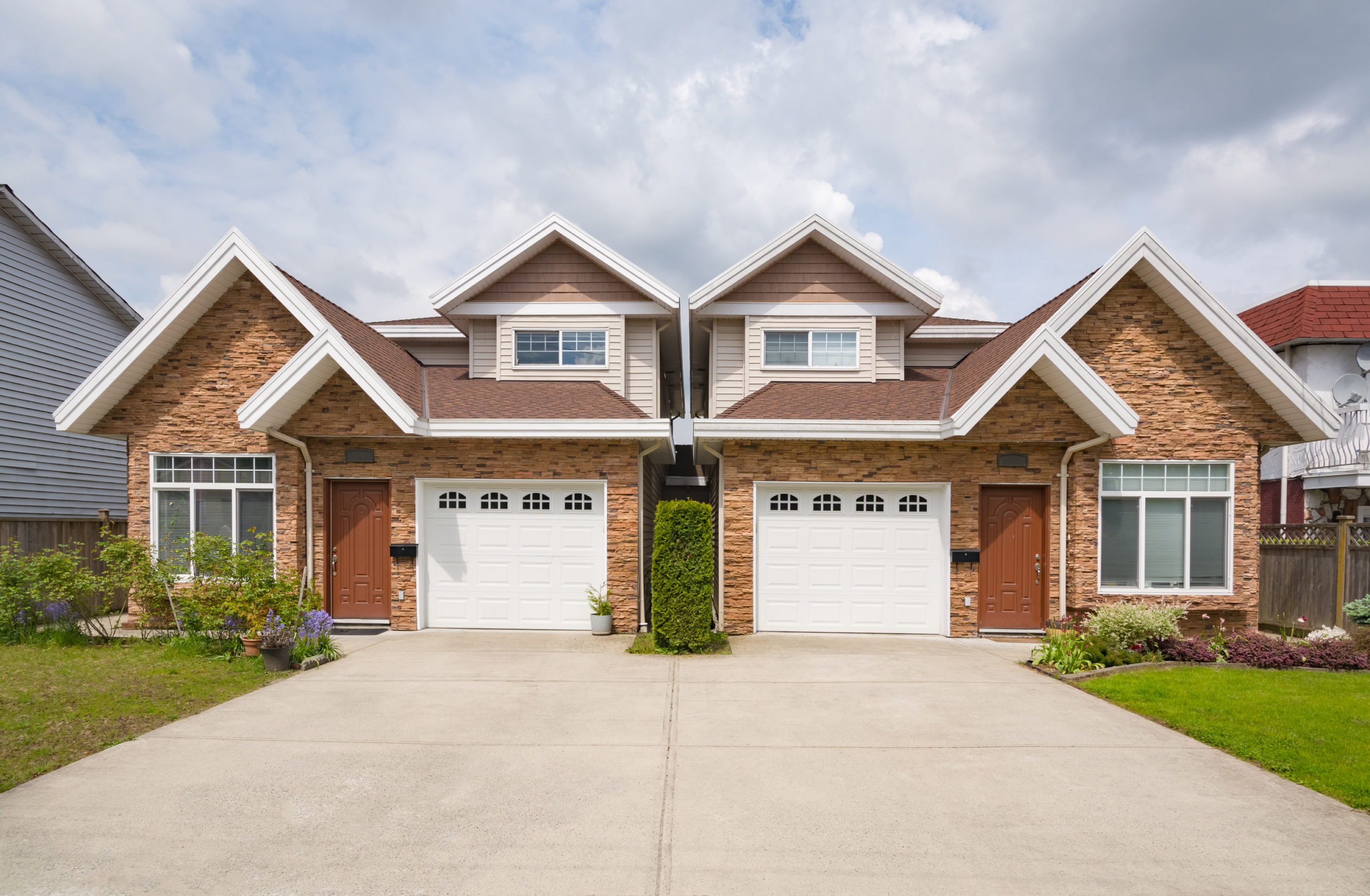 A two story brick house with two garages